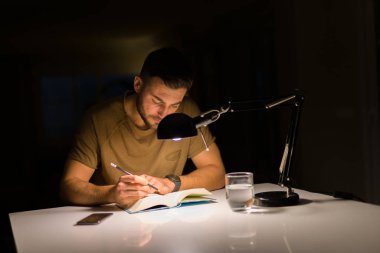 Geceleri bir kitap okuma evde eğitim genç yakışıklı adam