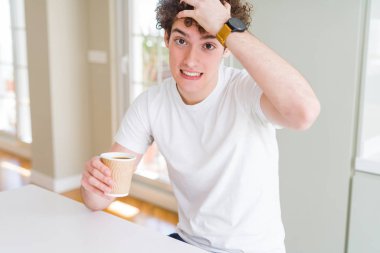 Evde kahve içen genç adam eliyle stresli, utanç ve sürpriz yüz, kızgın ve sinirli. Korku ve hata için üzgün.