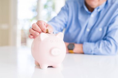 Bir adam bir sikke tasarruf olarak kumbara içinde koyarak kapatın