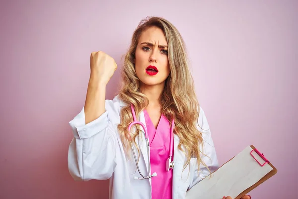 Jovem Bela Médica Mulher Segurando Prancheta Sobre Rosa Isolado Fundo — Fotografia de Stock