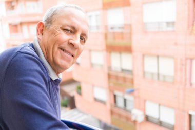 Yakışıklı orta yaş kıdemli neşeli, mutlu gülümseyen adam ve yerine koymak