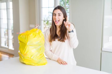 Güzel genç kadın çöp konteynırı başarılı bir fikir ile parmak işaret çöpten dışarı alarak. Çıkıldı ve mutlu. Bir numara.