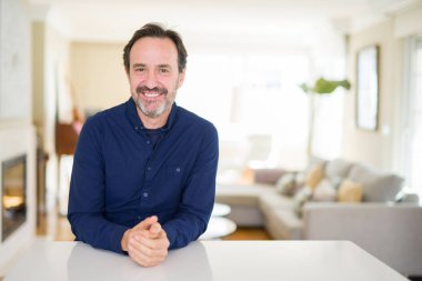 Yakışıklı orta yaş erkek evde yüzünde mutlu ve güzel bir gülümseme ile. Şanslı kişi.