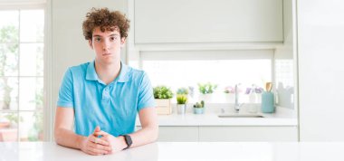 Evde Genç yakışıklı adamın geniş çekim komik yüzü ile yanakları kabarık. Ağız hava ile şişirilmiş, çılgın ifade.