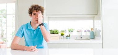 Evde Genç yakışıklı adam geniş çekim yüz ve sürpriz duygu kendine güvenen gülümseme ile el ile bir göz kaplayan.