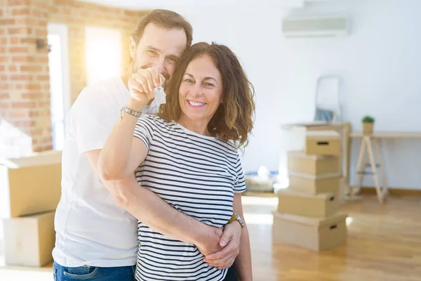 Orta yaş Senior romantik çift Holding ve yeni bir eve taşımak için mutlu gülümseyen ev anahtarlarını gösteren