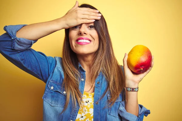 Young Beautiful Woman Eating Fresh Healthy Mango Yellow Background Stressed — Stock Photo, Image