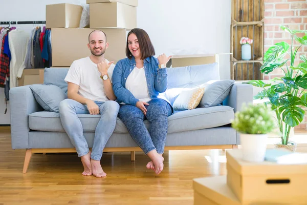 Junges Paar Sitzt Auf Dem Sofa Inmitten Von Kartons Die — Stockfoto