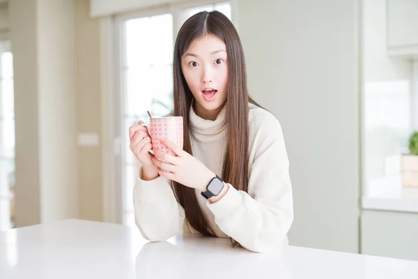 Красивая Азиатка Пьет Чашку Кофе Испуганная Шока Удивленным Лицом Напуганная — стоковое фото