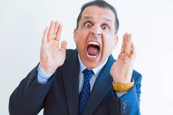 Middle age man shouting crazy with hands over mouth over white w — Stock Photo, Image