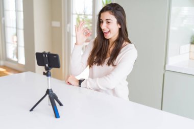 Güzel genç kadın kayıt selfie video ile Smartphone Webcam yapıyor ok işareti ile parmaklar, mükemmel sembolü