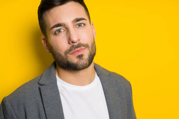 stock image Young handsome man possing and modeling over yellow isolated background