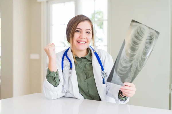 Hermosa Joven Doctora Mirando Radiografía Del Pecho Gritando Orgullosa Celebrando —  Fotos de Stock