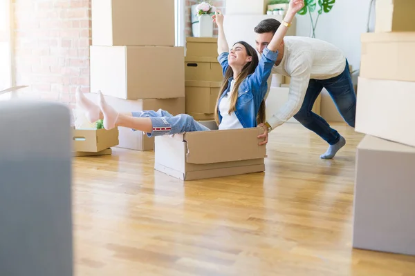 Pareja Joven Mudándose Nuevo Hogar Divirtiéndose Montando Cajas Cartón — Foto de Stock