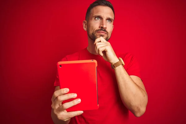 Hombre Joven Usando Tableta Táctil Digital Sobre Fondo Rojo Aislado —  Fotos de Stock