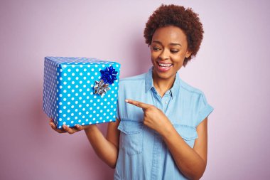 Afrika Amerikan kadın tutan Doğum günü hediyesi üzerinde pembe izole arka plan çok mutlu işaret ile el ve parmak