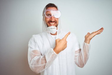 İzole arka plan üzerinde profesyonel çalışan ekipman koruması giyen ressam adam hayran ve kamera gülümseyen el ile sunmak ve parmak ile işaret ederken.