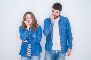 Beyaz izole arka plan üzerinde birlikte ayakta genç güzel çift vurguladı ve ağız ısırma çivi elleri ile sinir bakıyor. Anksiyete sorunu.