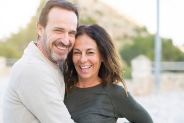 Güneşli bir günde gülümseyen ve sarılarak romantik çift