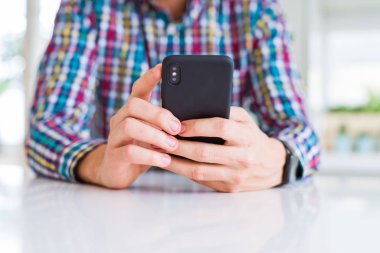 Smartphone kullanarak ve gülümseyen adam elinde yakın çekim