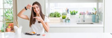 Güzel genç kadının geniş açı resmi teslimat gülümseyen anne ve parmaklarla mutlu yüz ile çerçeve yapmak Asya Suşi yeme. Yaratıcılık ve Fotoğrafçılık konsepti.