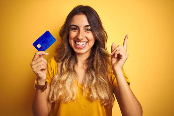 Młoda Piękna Kobieta Trzyma Kartę Kredytową Żółtym Białym Tle Bardzo — Zdjęcie stockowe