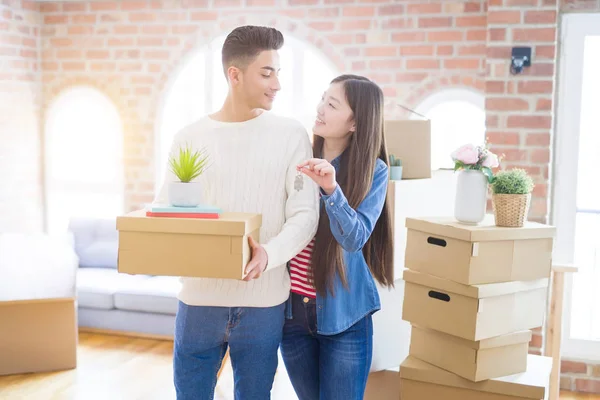 Joven pareja asiática sosteniendo llaves de nueva casa, sonriendo feliz y —  Fotos de Stock