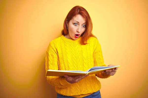 Junge Rothaarige Studentin Liest Buch Steht Über Gelbem Isolierten Hintergrund — Stockfoto