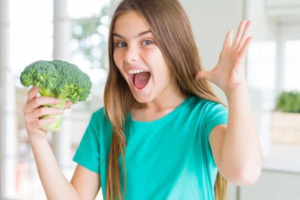 美丽的年轻女孩吃新鲜的花椰菜很高兴和兴奋 胜利者的表情庆祝胜利尖叫与大大的微笑和举手 — 图库照片