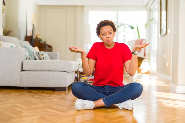 Joven Mujer Afroamericana Hermosa Sentada Suelo Casa Expresión Despistada Confusa —  Fotos de Stock