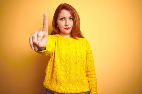 美丽的红发女人穿着冬季毛衣站在孤立的黄色背景指指头和愤怒的表情 显示没有手势 — 图库照片