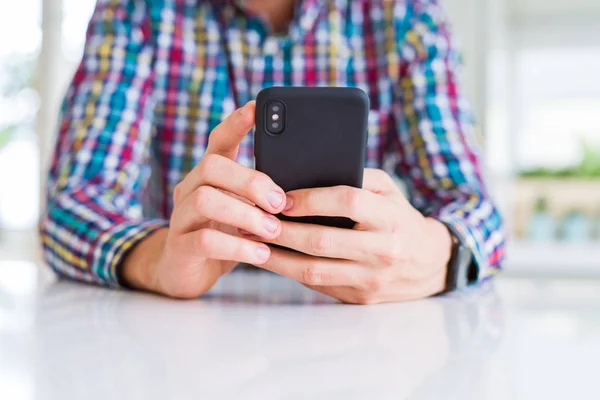 Primer plano de las manos del hombre usando el teléfono inteligente y sonriendo —  Fotos de Stock