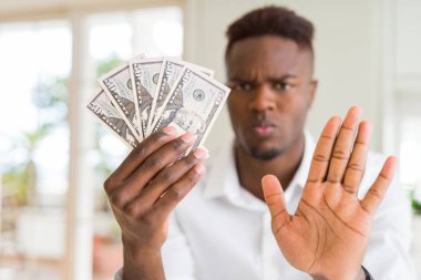 African American Man Holding 50 dolar banka notları açık el ile ciddi ve emin ifade, savunma jest ile stop işareti yapıyor