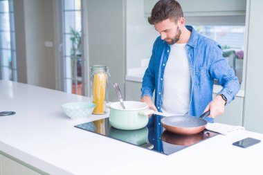 Evde makarna pişiren yakışıklı adam.