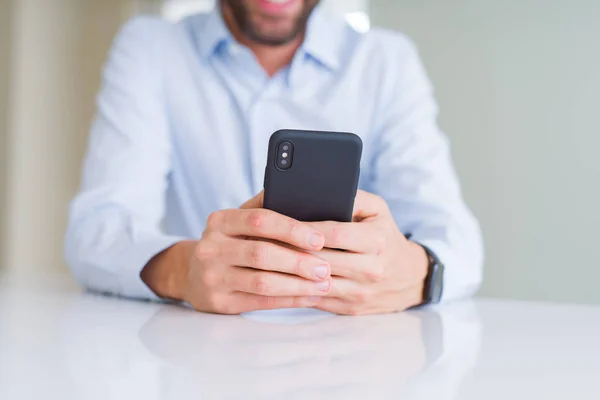 Az ember kezét használ smartphone és mosolyogva közelről — Stock Fotó