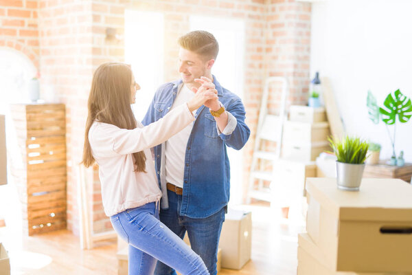 Beautiful young couple having fun dancing at new apartment, cele