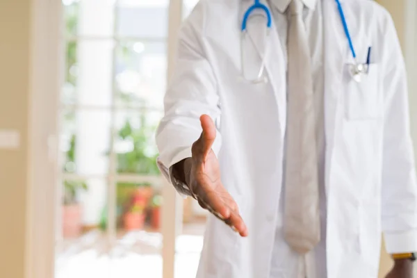 Close up of african doctor offering hand for welcome hand shake and smiling