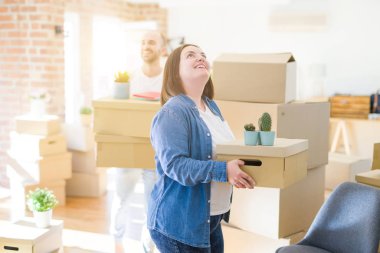 Genç çift yeni bir eve hareket, mutlu tutan karton kutular gülümseyen