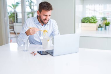 İş adam yeme Asya erişte yemek sırasında çalışma u götürün