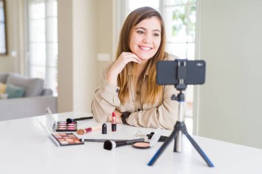 Güzel genç etki unsuru kadın kayıt video öğretici yüz, doğal ifade üzerinde gülümseme ile kenara bakarak makyaj. Güven gülüyor.