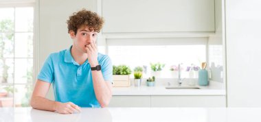 Evde Genç yakışıklı adam geniş çekim vurgulandı ve ağız ısırma çivi eller ile gergin bakıyor. Anksiyete sorunu.