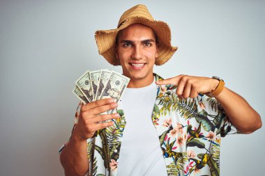 Tatillerde genç adam beyaz izole arka plan üzerinde dolar banka notları tutan çok mutlu el ve parmak ile işaret