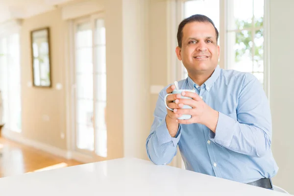 Homem de meia idade desfrutando e bebendo uma xícara de café em casa — Fotografia de Stock