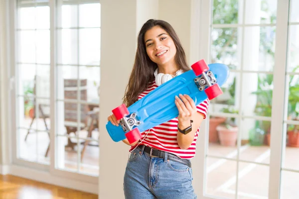 Hermosa mujer skater sonriendo amistoso de pie con monopatín — Foto de Stock