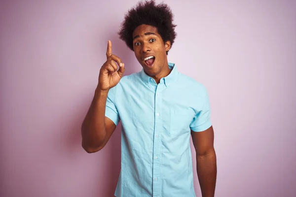 年轻的美国男子与非洲头发穿着蓝色衬衫站在孤立的粉红色背景指向手指与成功的想法 退出和快乐 — 图库照片