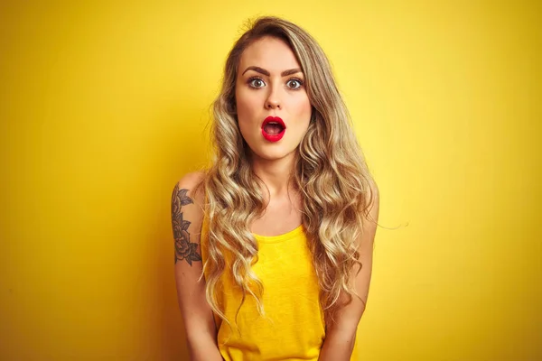 stock image Young beautiful woman wearing t-shirt standing over yellow isolated background afraid and shocked with surprise expression, fear and excited face.