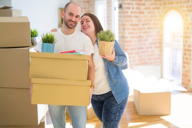 Genç çift yeni bir eve hareket, mutlu tutan karton kutular gülümseyen