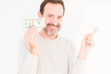 İzole arka plan üzerinde yirmi dolar banka notu tutan kıdemli adam çok mutlu yan el ve parmak ile işaret