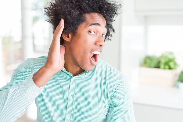 エレガントなシャツを着たアフリカ系アメリカ人のビジネスマンは 噂やゴシップに耳を傾けて耳をつんざく 聴覚障害の概念 — ストック写真