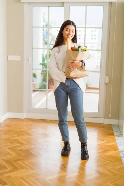 Bella giovane donna sorridente in possesso di un sacchetto di carta pieno di fresco — Foto Stock